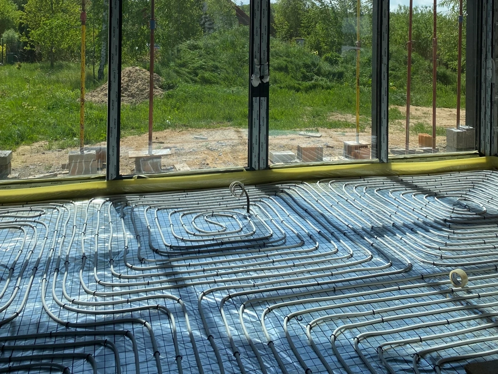 Instalacja ogrzewania podłogowego ułożona na izolacji termicznej przed wylaniem posadzki