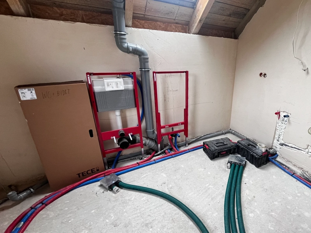 Stelaże podtynkowe WC i rozprowadzenie instalacji hydraulicznych w pomieszczeniu na poddaszu