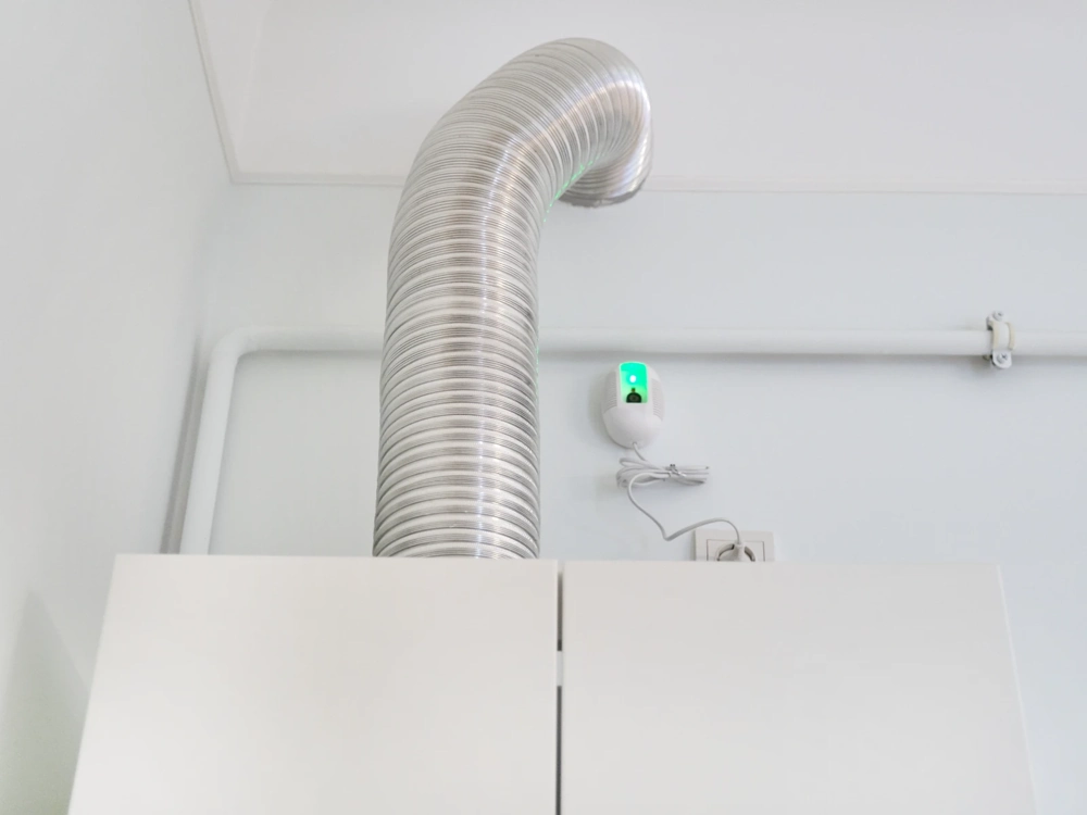 Elastyczny kanał wentylacyjny rekuperacji zamontowany przy suficie nad szafką