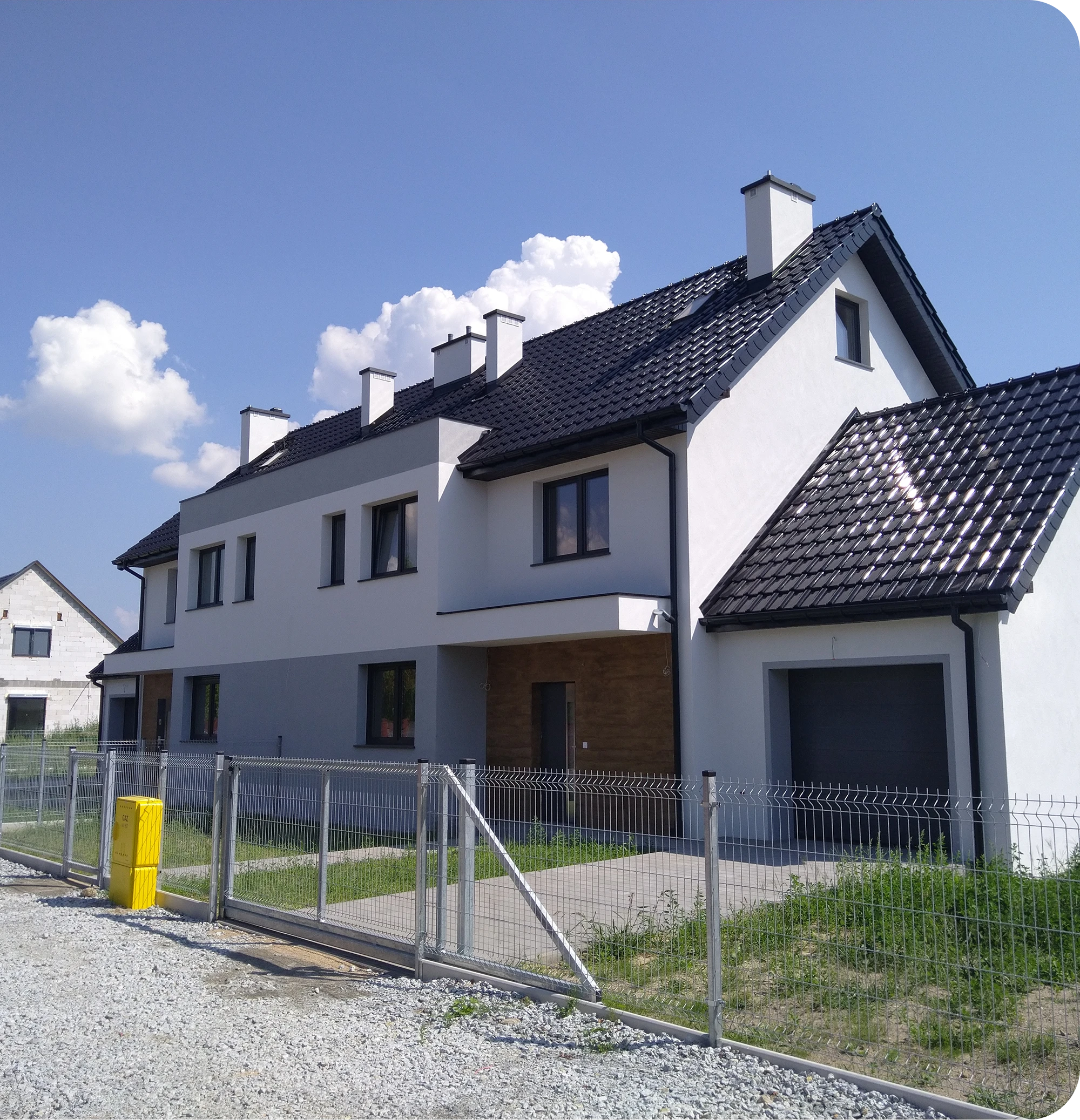Szeregowa zabudowa z nowoczesną elewacją domu w bieli i szarości, czarny dach