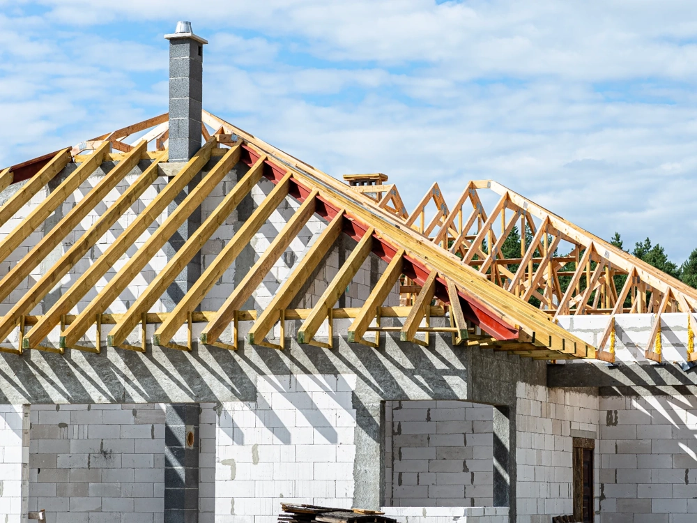 Drewniana więźba dachowa nad murowanymi ścianami nośnymi z bloczków