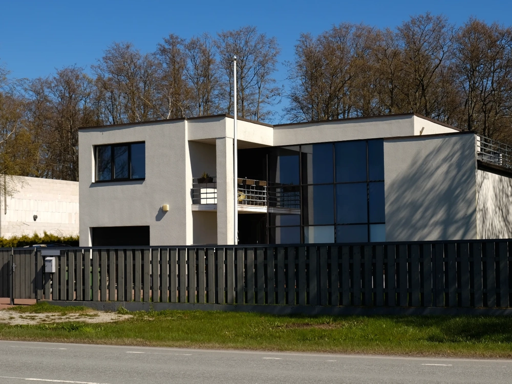 Panelowe ogrodzenie metalowe przed nowoczesnym domem z białą elewacją